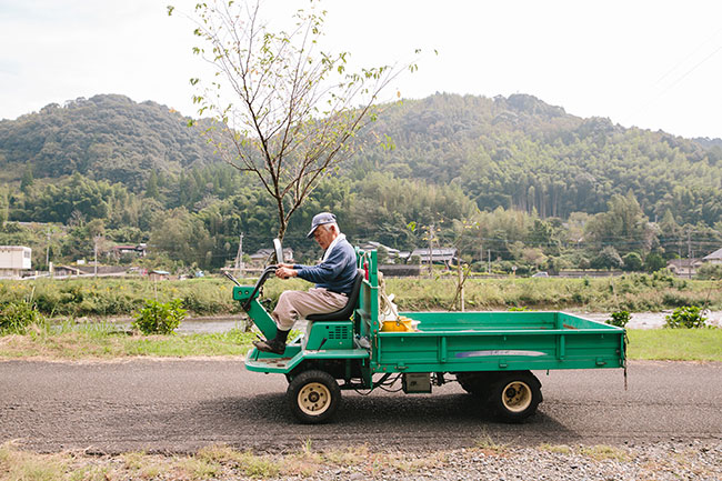 トラクターに乗るおじいさんの写真